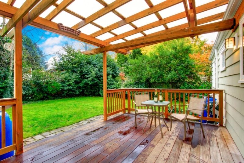 Timber deck with an attached pergola overlooking a lawn and garden