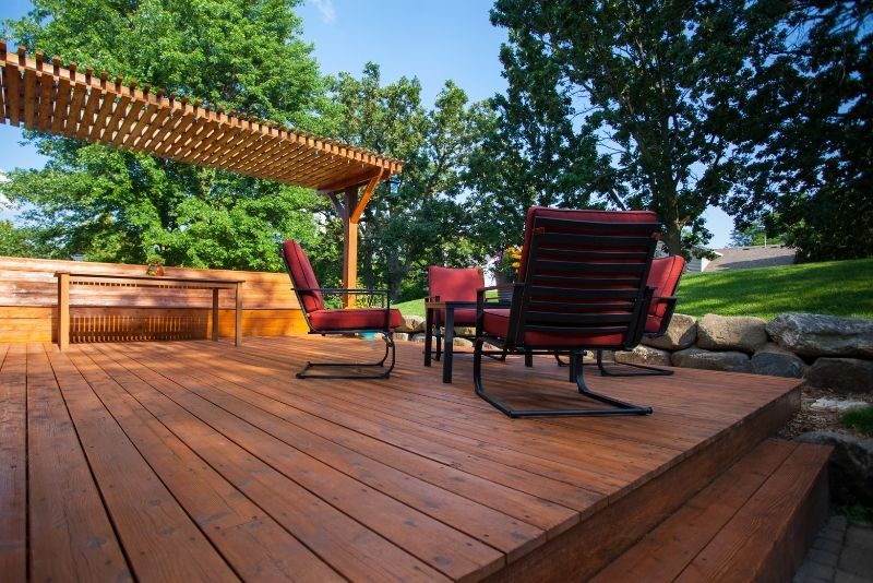 Timber deck with an attached pergola, lounge chairs and garden views