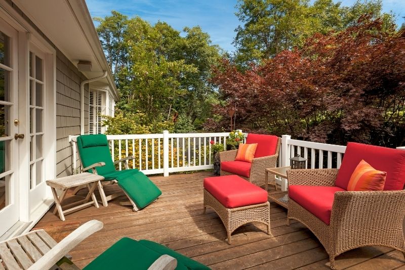 large sofa on a decking area with several plants outside