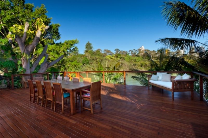 Spacious timber deck with a large outdoor dining table and built-in bench seating